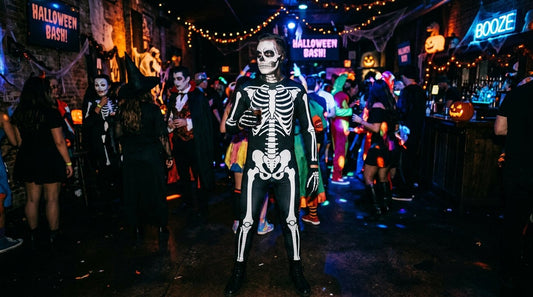 A person in a full black-and-white skeleton bodysuit costume at a dark Halloween party