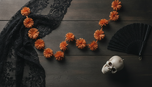 Day of the Dead costume styling props laid out including a lace veil, paper marigolds and a skull candle